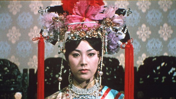 Film still from RUTEN NO OHI: A young woman with a magnificent headdress looks into the camera.