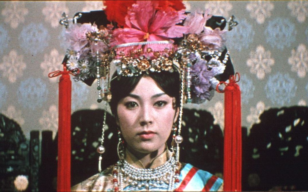 Film still from RUTEN NO OHI: A young woman with a magnificent headdress looks into the camera.