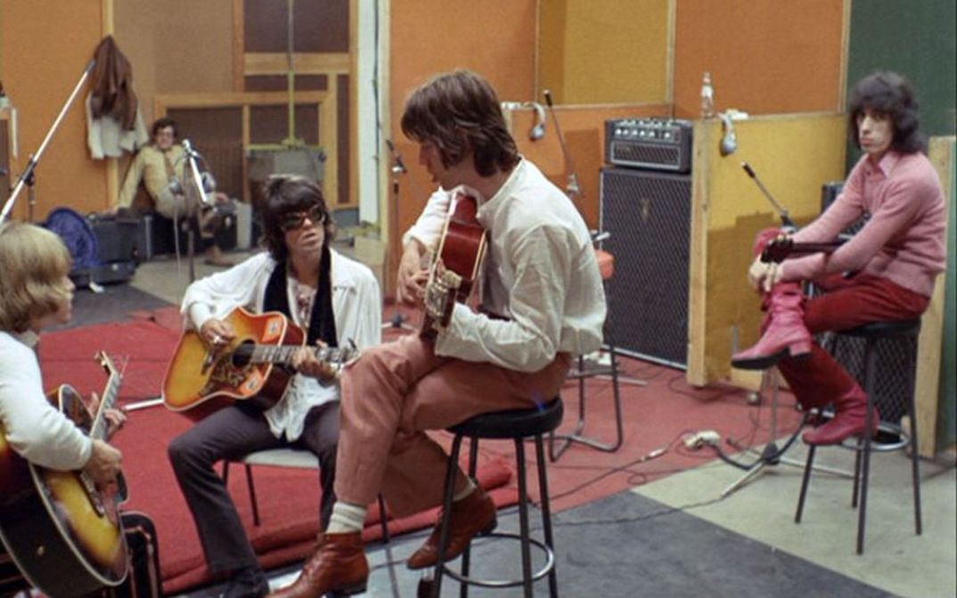 Film still from ONE PLUS ONE: The Rolling Stones making music in a recording studio.