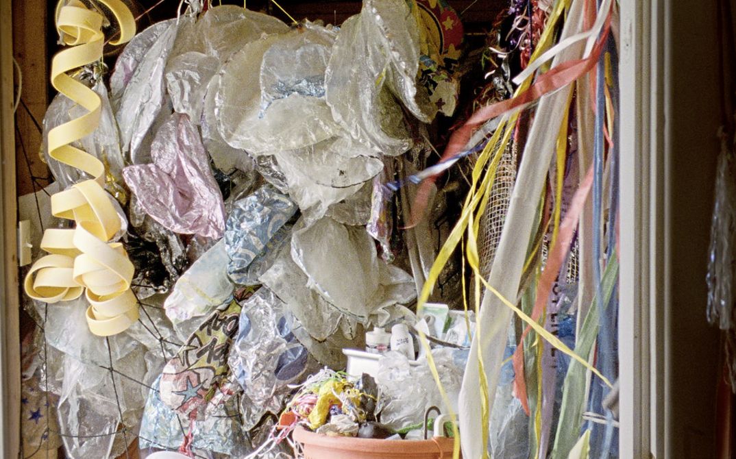 Still from the film "Geographies of Solitude" by Jacquelyn Mills. We see a drawer full of colourful plastic bags and ribbons. 