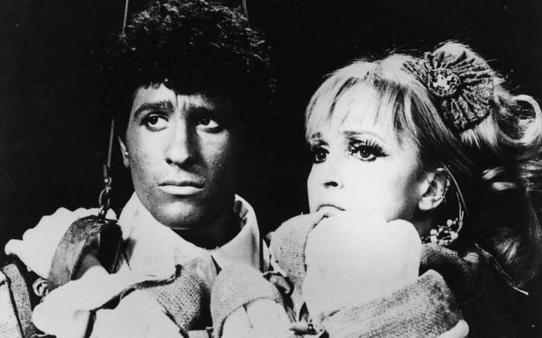 Film still from CHE COSA SONO LE NUVOLE: A man and a woman next to each other in close-up, both have sad faces.