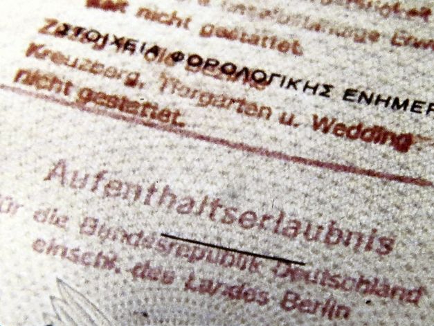 Filmstill from „Aufenthaltserlaubnis" by Antonio Skármeta. Close-up of a residence permit issued by the Federal Republic of Germany. The printed font is red.