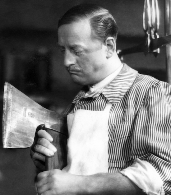 Film still from DAS BEIL VON WANDSBEK: A butcher looks scrutinizingly at the axe in his hand.