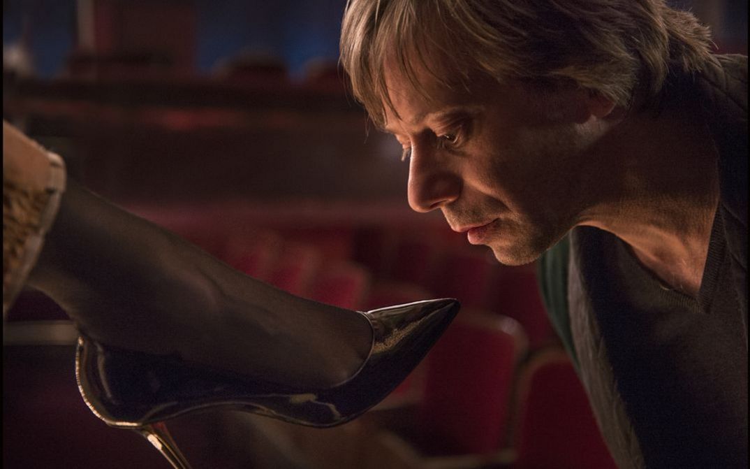 Film still from LA VÉNUS À LA FOURRURE. Mathieu Amalric is about to kiss a woman