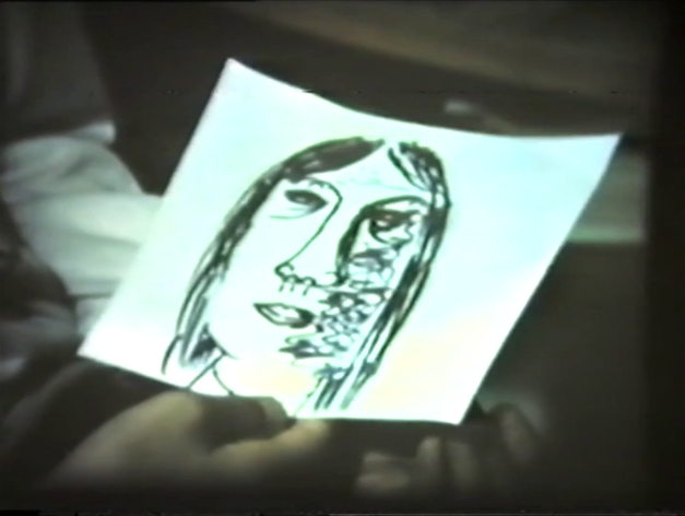 Filmstill aus FRAUEN IN BERLIN: Eine Hand hält eine Zeichnung eines Frauenkopfes.