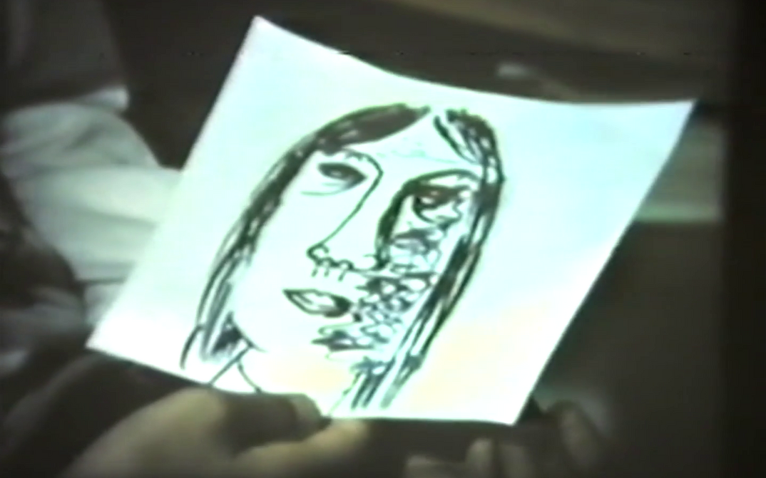 Filmstill aus FRAUEN IN BERLIN: Eine Hand hält eine Zeichnung eines Frauenkopfes.