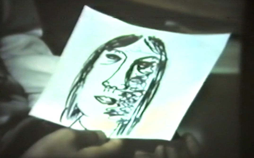 Filmstill aus FRAUEN IN BERLIN: Eine Hand hält eine Zeichnung eines Frauenkopfes.