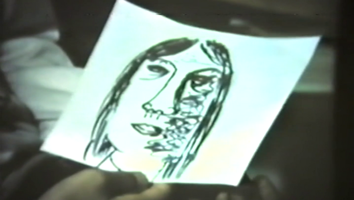 Filmstill aus FRAUEN IN BERLIN: Eine Hand hält eine Zeichnung eines Frauenkopfes.