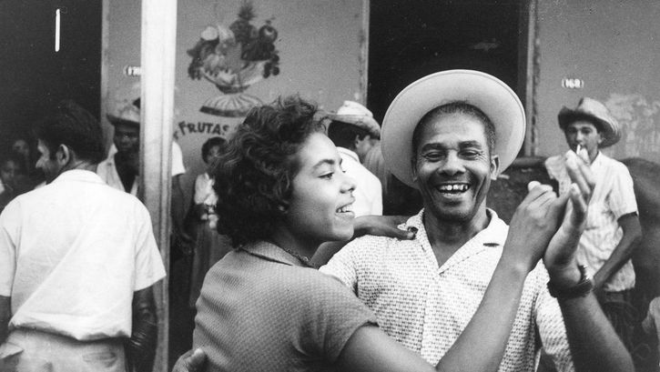 Film still from SALUT LES CUBAINS. A couple dancing and laughing.