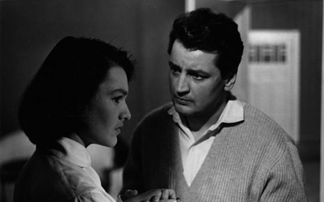 Filmstill aus BEGEGNUNG IM ZWIELICHT: Eine Mann und eine Frau stehen einander zugewandt.