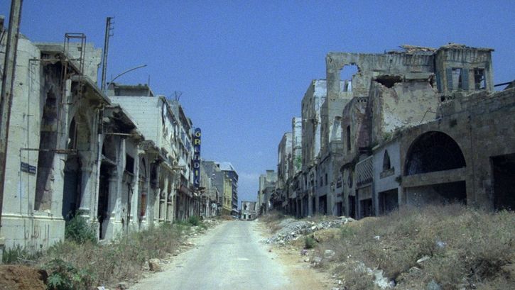 Filmstill aus BEIRUT, THE ENCOUNTER. Eine leere Straße gesäumt von Häusern in Ruinen.