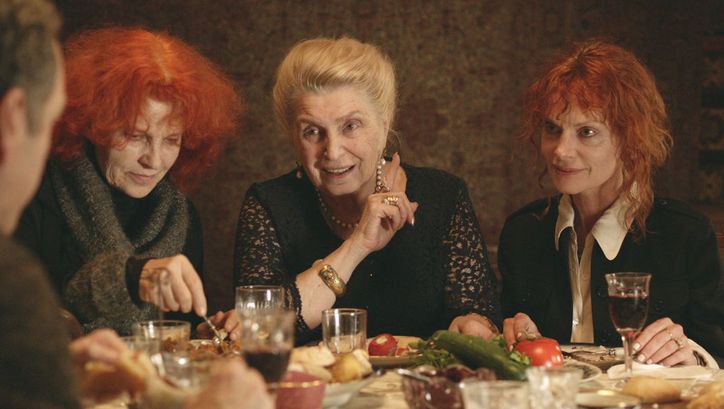 Filmstill aus THE GOLDEN THREAD. Drei Frauen sitzen an einem gedeckten Tisch.