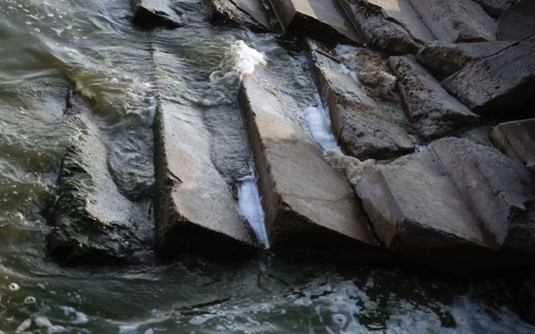 Film still from VOR ZEIT. Semi-destroyed stairs washed by water.