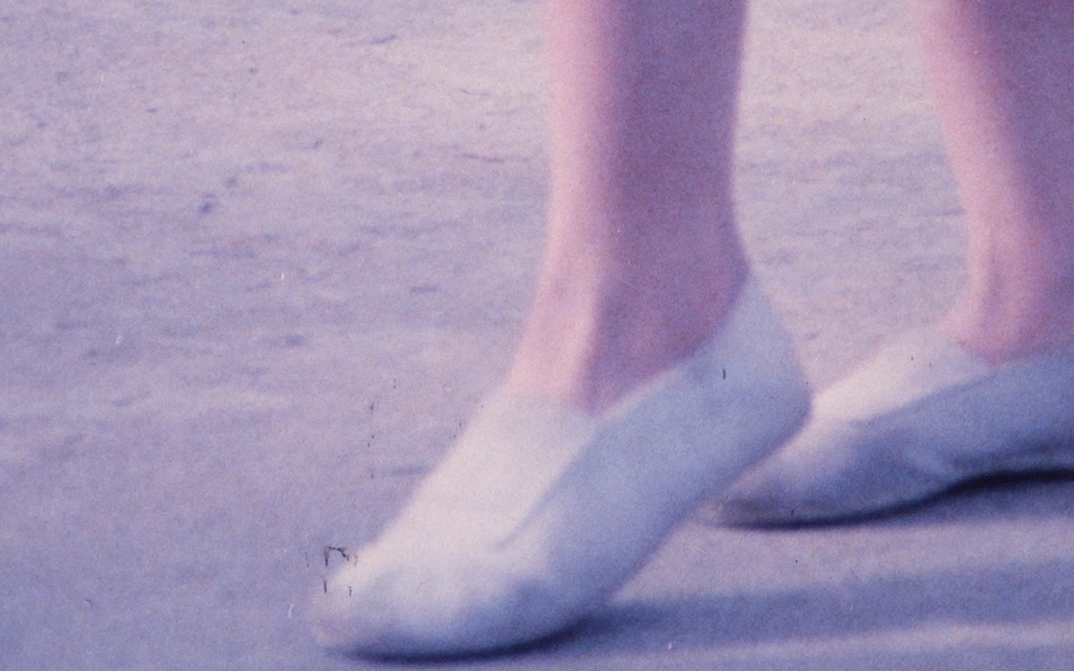 Film still from VIA DOLOROSA: You can see a pair of feet in gym shoes.