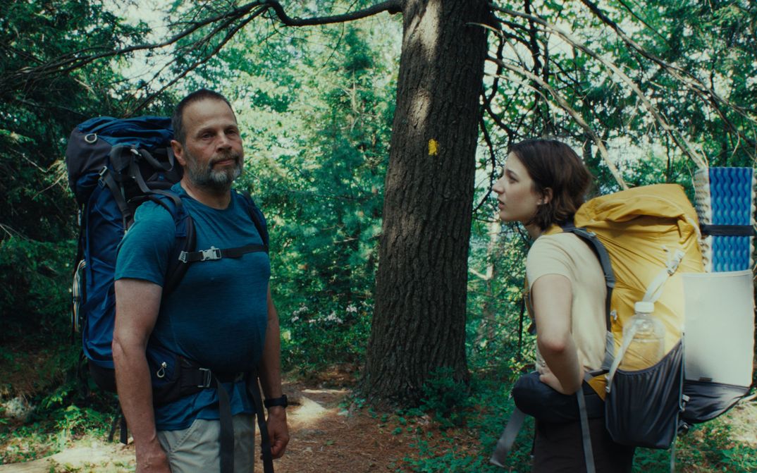 Filmstill aus GOOD ONE: Eine Teenagerin und ihr Vater stehen mit großen Wanderrucksäcken im Wald.