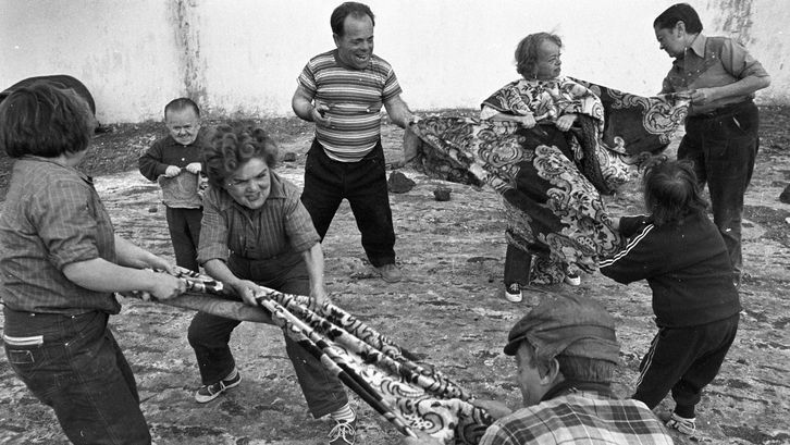 Film still from AUCH ZWERGE HABEN KLEIN ANGEFANGEN: A group of people of short stature pull on two large cloths.