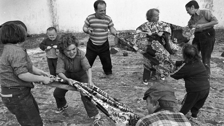 Filmstill aus AUCH ZWERGE HABEN KLEIN ANGEFANGEN: Eine Gruppe von kleinwüchsigen Menschen ziehen an zwei großen Tüchern.