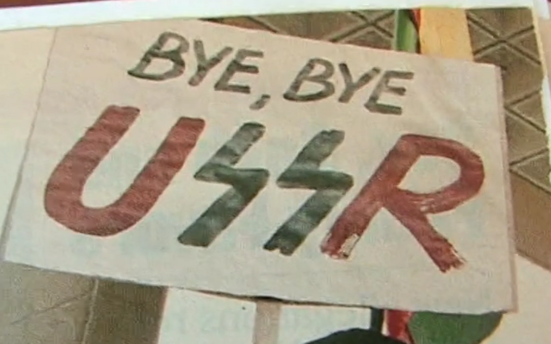 Filmstill aus LITHUANIA AND THE COLLAPSE OF THE USSR. Ein Plakat mit dem Schriftzug "Bye, bye USSR".