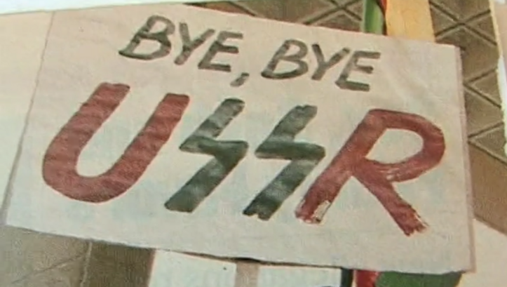 Film still from LITHUANIA AND THE COLLAPSE OF THE USSR. A poster with the words "Bye, bye USSR".