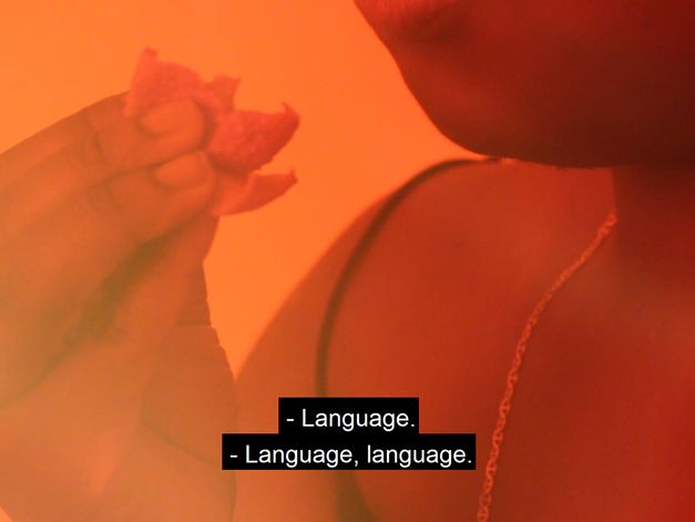 Still from the film "MU/T/T/ER" by Esther Kondo Heller. Close-up of a person putting food to their mouth, the face is not visible.