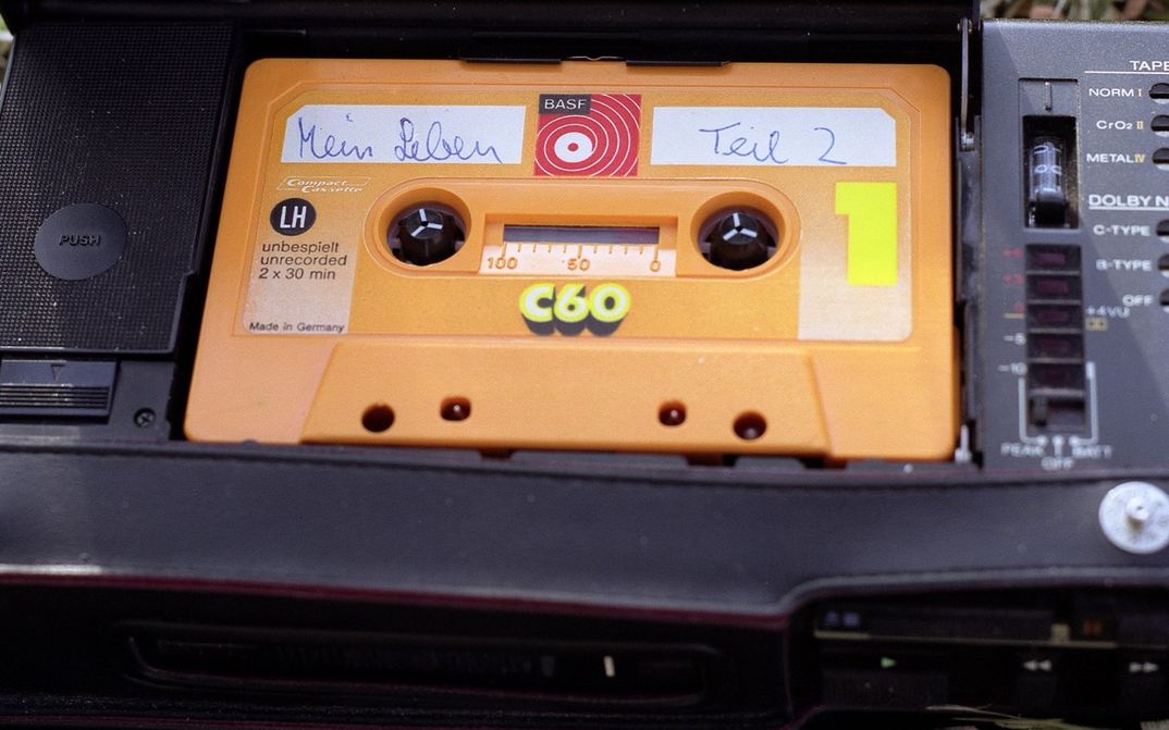 Still aus MEIN LEBEN TEIL 2: Eine gelbe Audiokassette ist handschriftlich mit dem Titel "Mein Leben Teil 2" versehen.