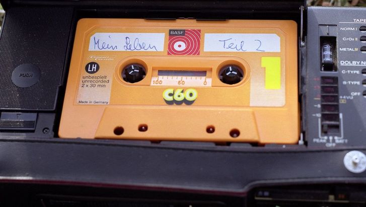 Still aus MEIN LEBEN TEIL 2: Eine gelbe Audiokassette ist handschriftlich mit dem Titel "Mein Leben Teil 2" versehen.
