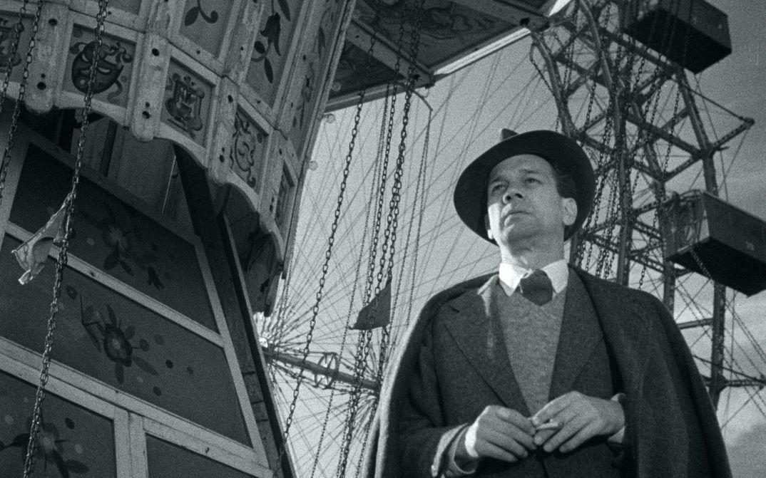 Film still from THE THIRD MAN: A man stands in front of a Ferris wheel.