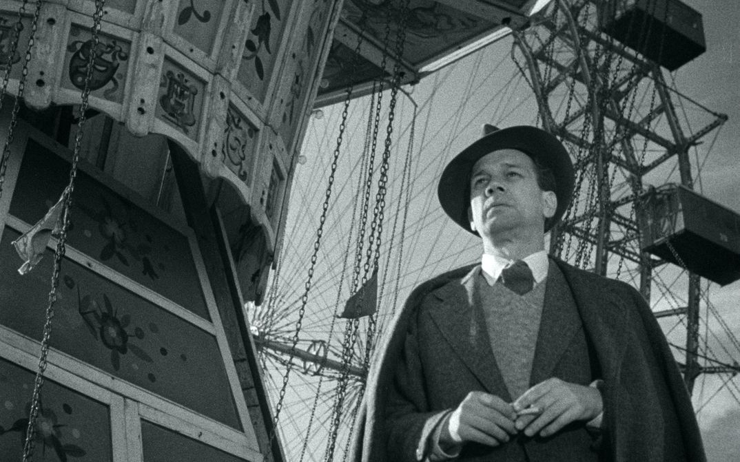 Filmstill aus DER DRITTE MANN: Ein Mann steht vor einem Riesenrad.