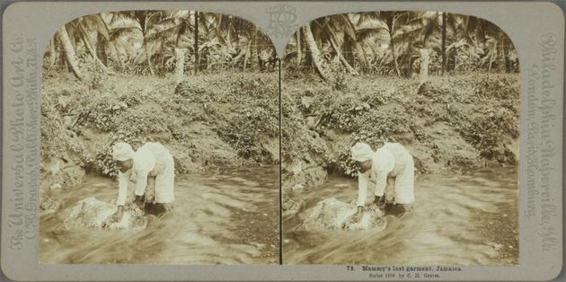 Die Postkarte zeigt zwei fast identische Bilder: Eine Schwarze, weiß gekleidete Figur steht knietief im Wasser eines Flusses und beugt sich über ein kaum sichtbares Stück weißen Stoffes, um diesen zu waschen.
