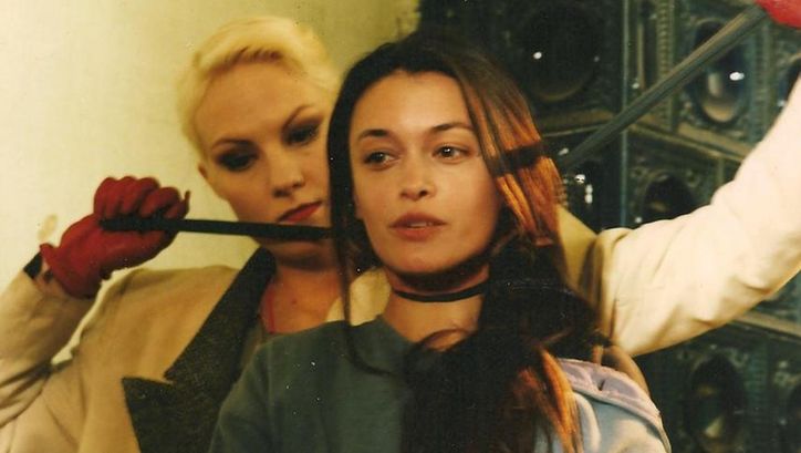 Film still from THREE STORIES: One woman stands behind another and strangles her with a stocking.