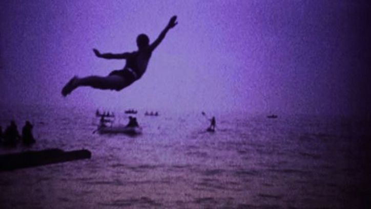 Filmstill aus LA BOCCA DEL LUPO: Monochrom eingefärbtes Bild eines Mannes, der ins Meer springt.