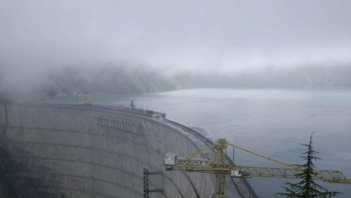 Filmstill aus WATER HAS NO BORDERS. Aufnahme eines riesigen Staudamms im Nebel.