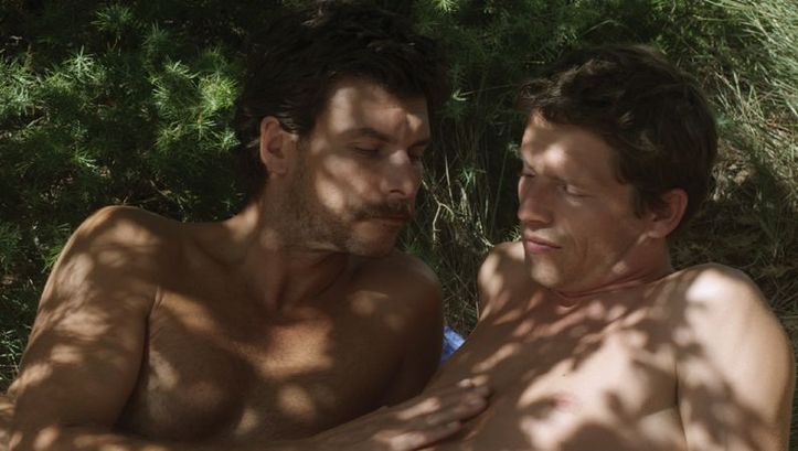 Filmstill aus L’INCONNU DU LAC: Zwei Männer liegen im Gras.