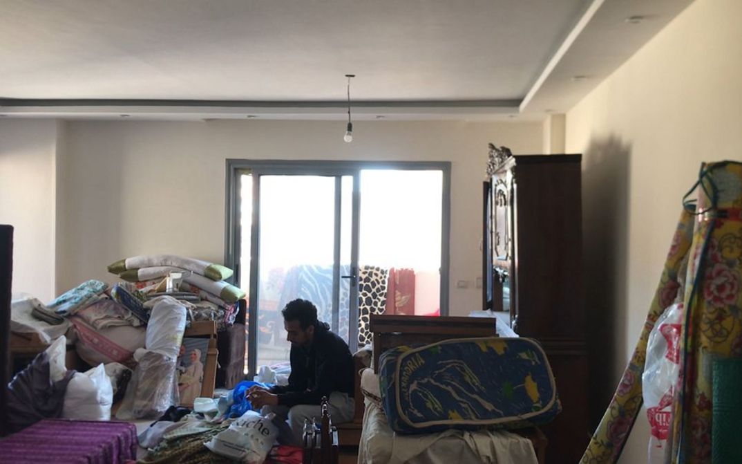 Filmstill aus dem Film „Akher Youm“ von Mahmoud Ibrahim. In einem mit Kartons und zum Umzug bereiten Möbeln überfüllten Wohnzimmer sitzt ein Mann inmitten des bevorstehenden Chaos.