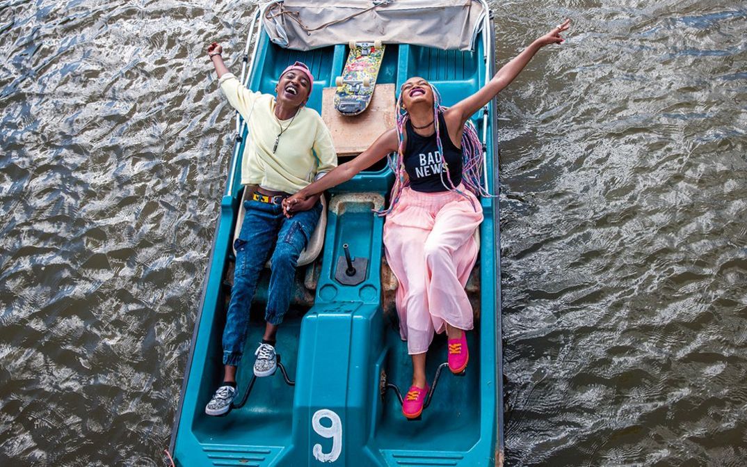 Film still from RAFIKI: Two young women in a boisterous mood in a pedalo.