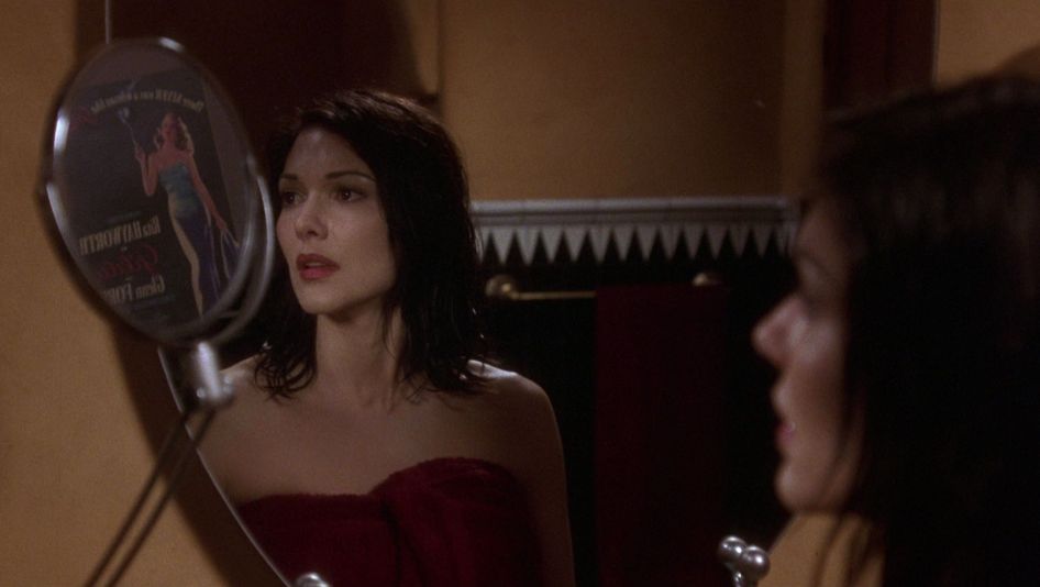 Film still from MULHOLLAND DRIVE: A dark-haired woman looks astonished and is doubled by a mirror.