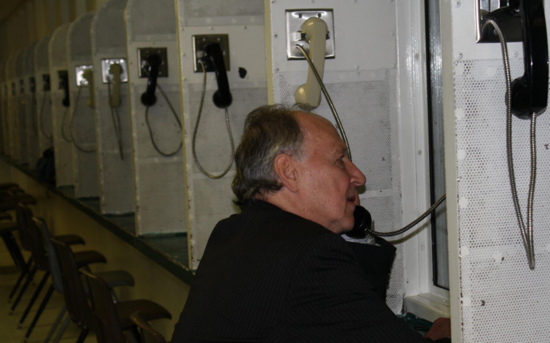 Film still from ON DEATH ROW (Part II): Werner Herzog on the phone in a prison.