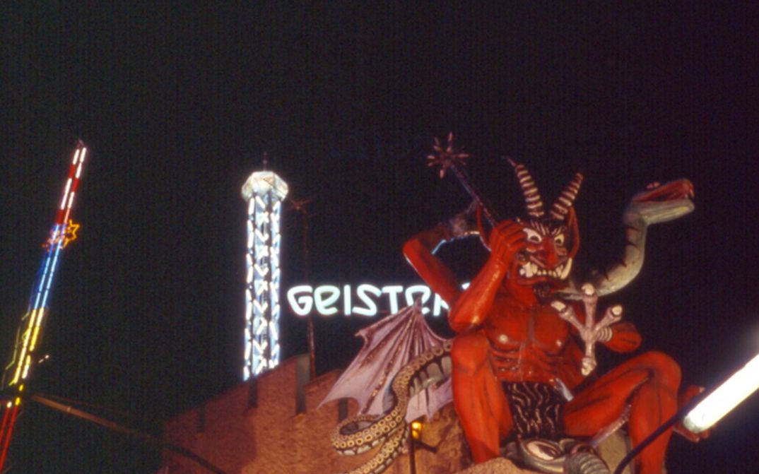 Filmstill aus PRATER: Das Fahrgeschäft eines Vergnügungspark mit der Figur eines Teufels.