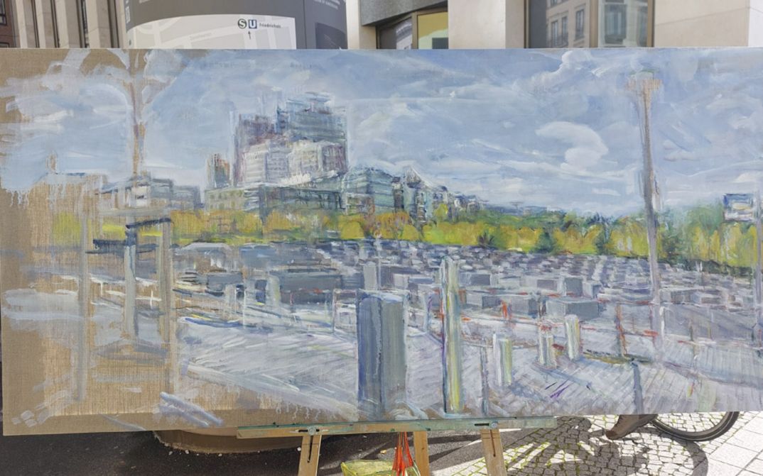 Film still from 2024 (2023) by Stefan Hayn. The image shows a painting on an easel in the urban space of Berlin.