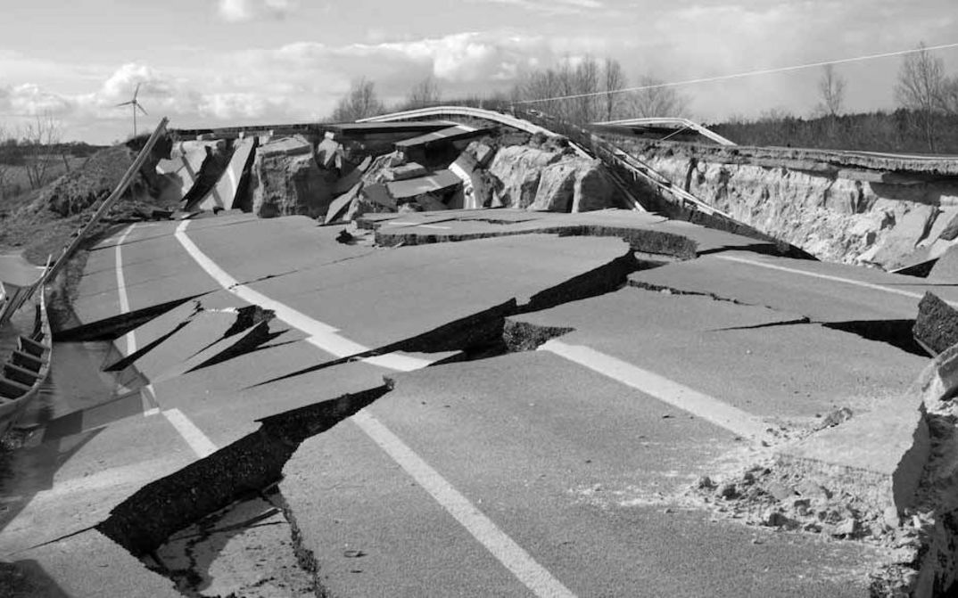 Filmstill aus MATERIAL: Man sieht eine durch Risse zerstörte Straße.