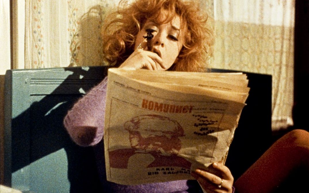 Filmstill aus W.R. – MISTERIJE ORGANIZMA. Eine Frau liest eine Zeitung.