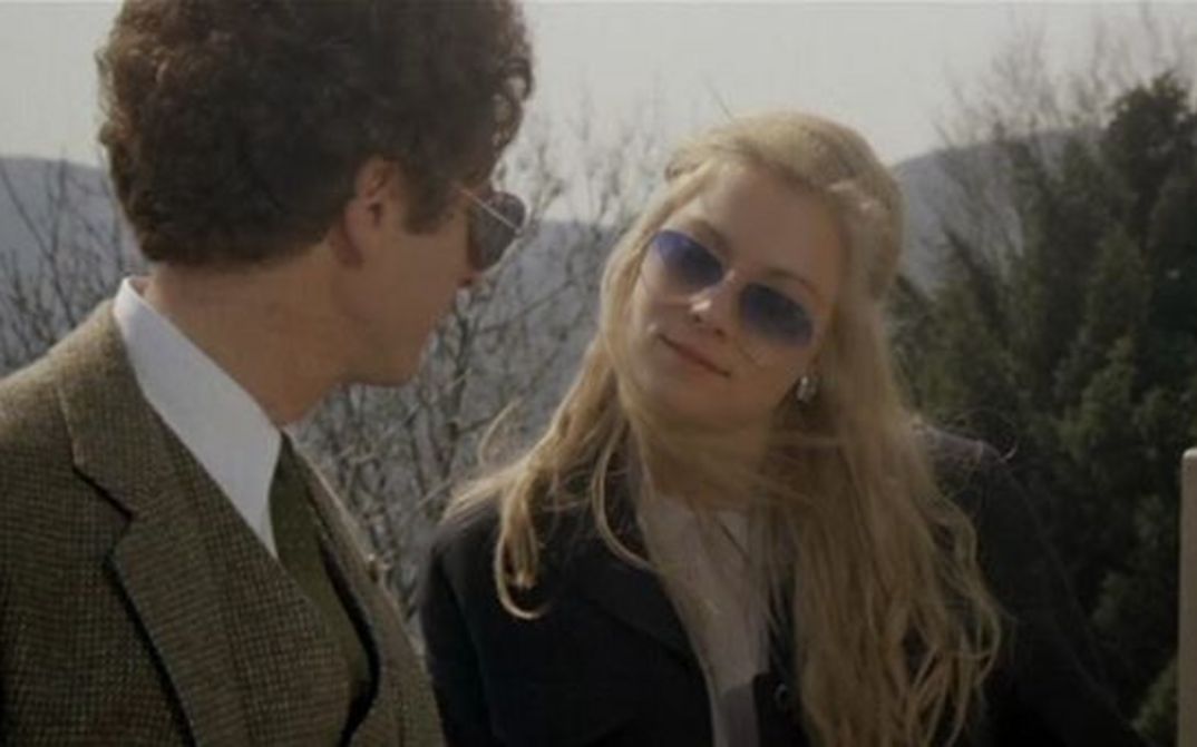 Filmstill aus BAD TIMING: Eine Frau und ein Mann stehen draußen und schauen sich an. Beide tragen Sonnenbrillen.