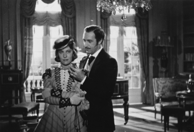 Filmstill aus ROMANZE IN MOLL: Ein Mann und eine Frau, beide elegant gekleidet, in einer großbürgerlichen Wohnung.