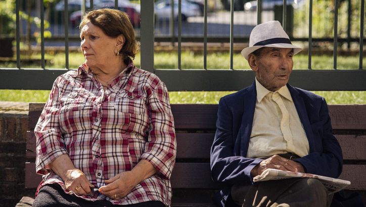 Filmstill aus THEIR ALGERIA. Ein älteres Paar sitzt auf einer Parkbank, sie blicken in entgegengesetzte Richtungen.