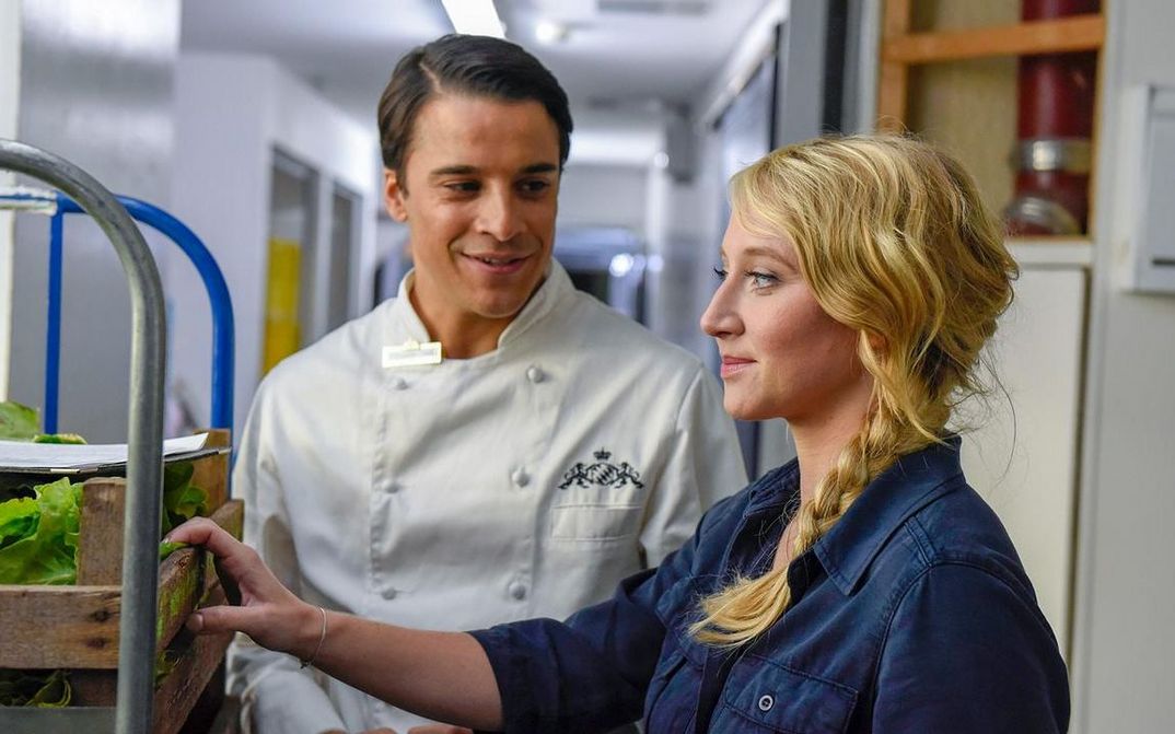 Film still from MEIN BLIND DATE MIT DEM LEBEN: A man and a woman delivering goods in a restaurant kitchen.