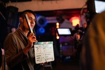 A behind-the-scenes shot of a person holding a clapperboard.
