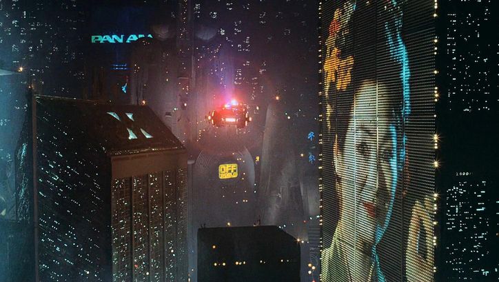 Filmstill aus BLADE RUNNER: Eine futuristische Szenerie mit beleuchteten Hochhäusern und Flugobjekten.