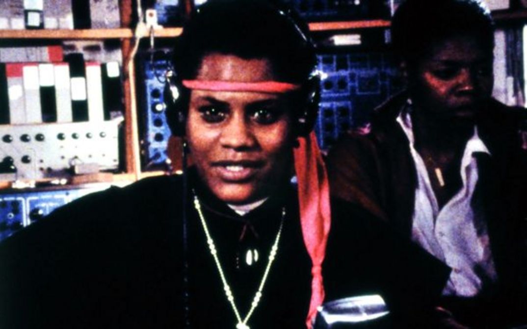 Film still from BORN IN FLAMES: Two women in a radio studio.