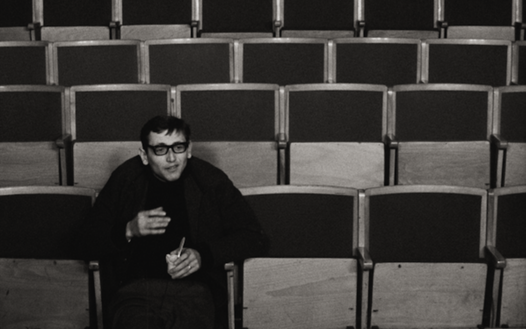 Filmstill aus EIN ANLASS ZUM SPRECHEN: Ein Mann sitzt alleine in einem Hörsaal.