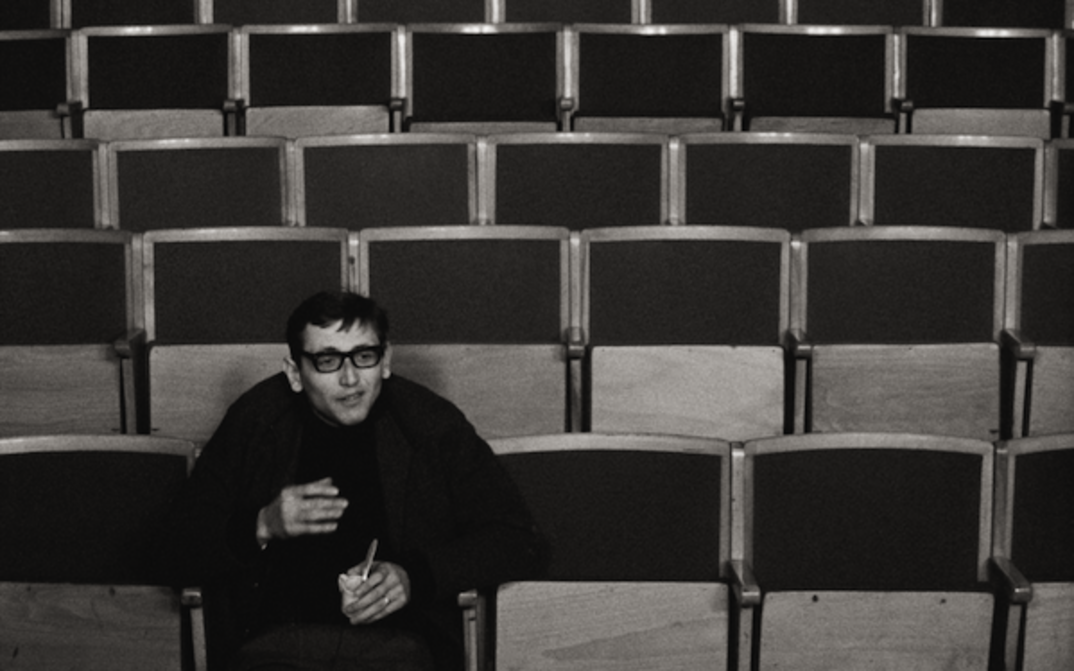 Film still from EIN ANLASS ZUM SPRECHEN: A man sits alone in an auditorium.